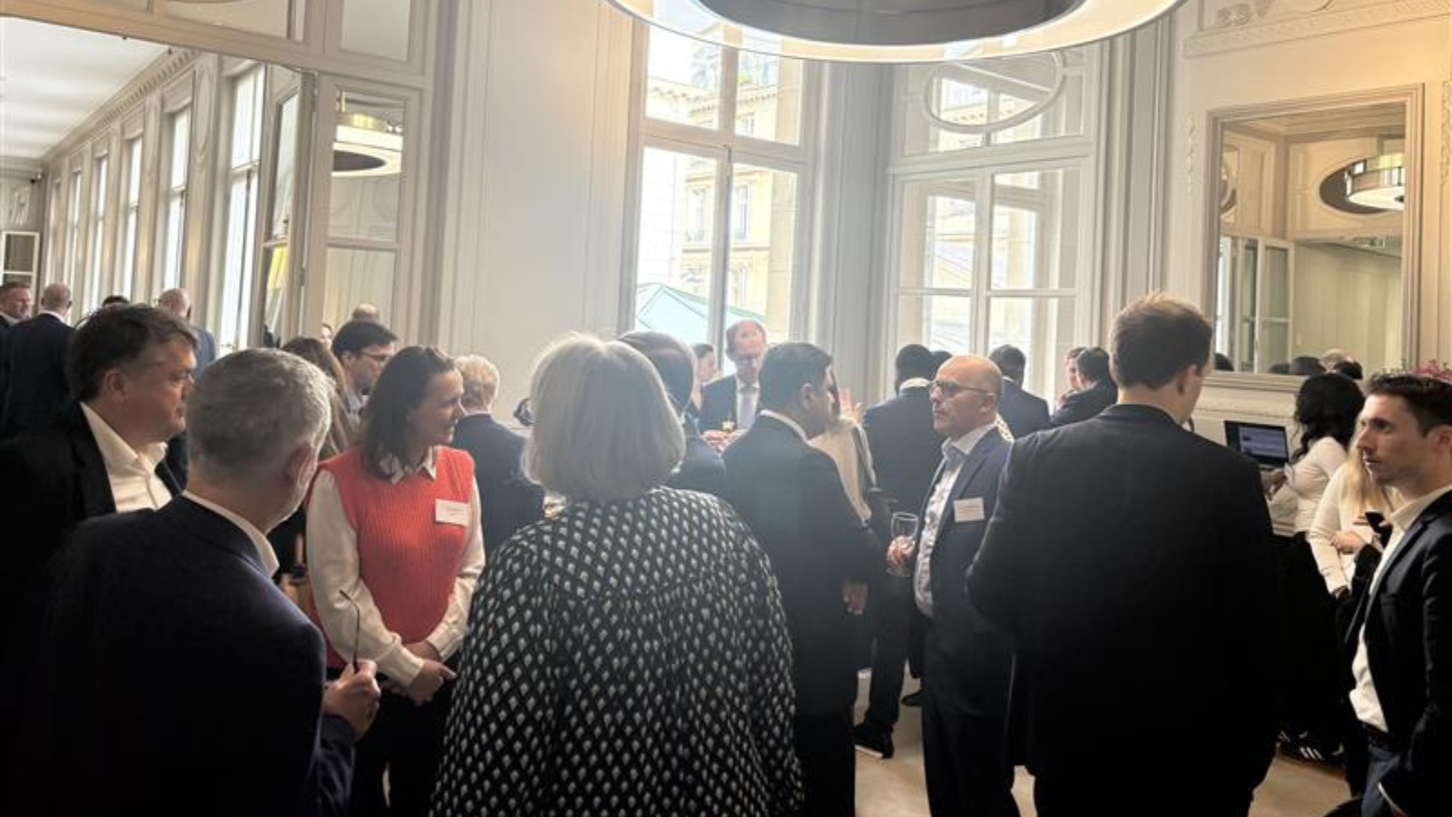 Room full of audience members and panellists gather in hall reception and network